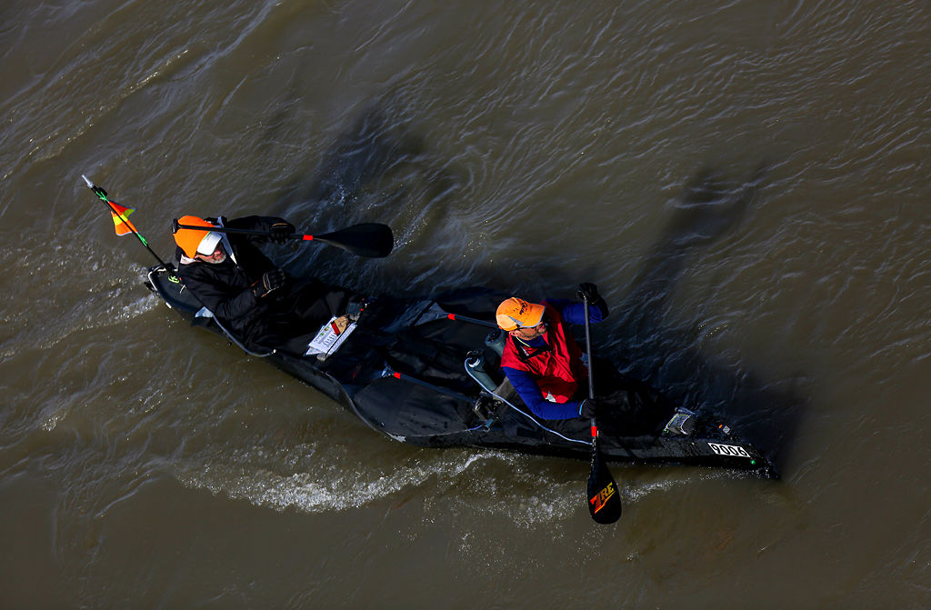 Steve Landick of and Jeremy Vore paddle their boat called Dark Knights down the Missouri River in Hermann